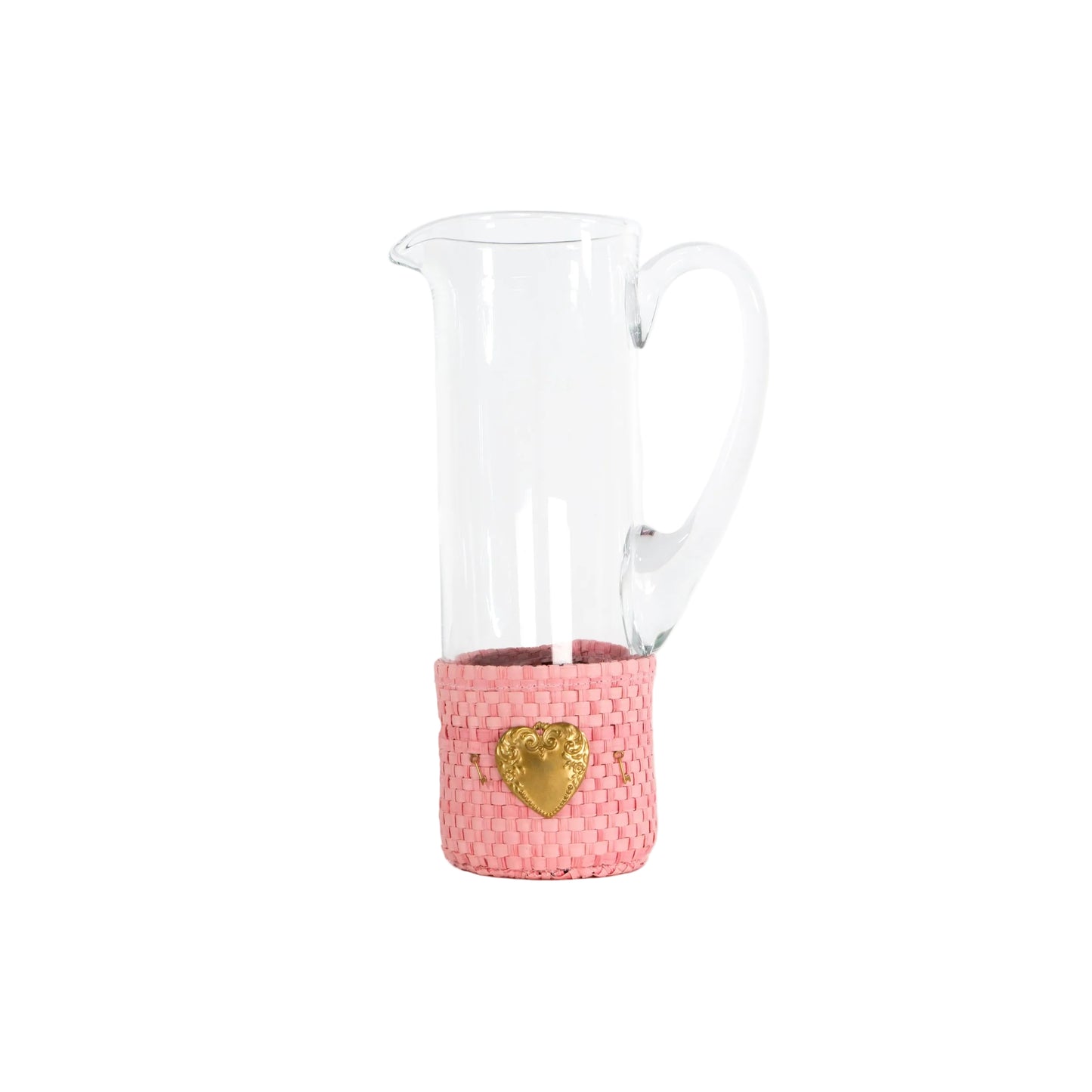 A clear glass pitcher with a pink woven sleeve around its base and a gold heart emblem, set against a plain white background.