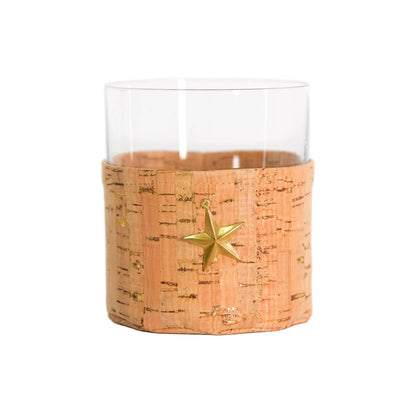 A clear glass tumbler with a natural cork sleeve featuring a gold star ornament, set against a plain white background.